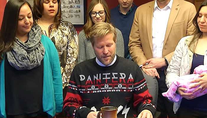 Mayor Tim Keller wears a Pantera Christmas sweater at a local bill-signing ceremony.